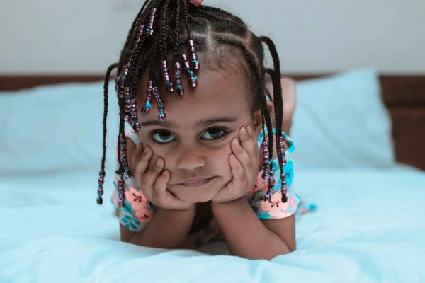 Cute little girl with braided hair laying on her stomach