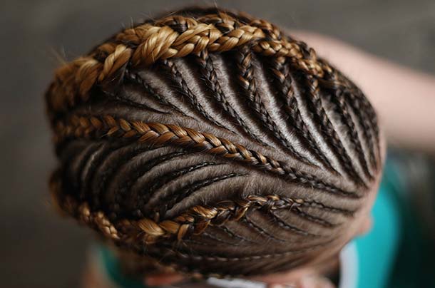 Top of a woman’s head showing intricate hair braiding